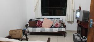 a living room with a couch with pillows on it at Casa Litoral Sul in Peruíbe