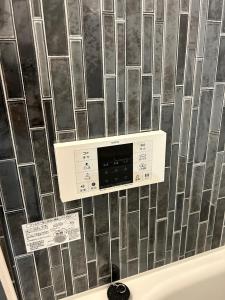 een badkamer met een muur met een fornuis en een muur bij One Point Five in Tokyo