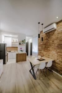 eine Küche und ein Esszimmer mit einem Tisch und einer Ziegelwand in der Unterkunft Apartment British Square with parking in Zagreb