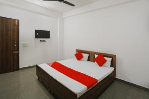 a bedroom with a bed and a tv on the wall at OYO Flagship Hotel Yuvraj Plaza in Garhi Harsāru