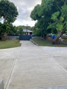 an empty sidewalk in a park with trees at L Oasis des kassaveries in Capesterre-Belle-Eau