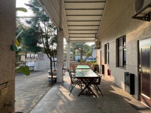 eine Terrasse mit einem Tisch und Stühlen an der Seite eines Gebäudes in der Unterkunft 日升咖啡民宿 in Gukeng