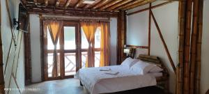 a bedroom with a bed and a large window at Villa Ester Hostel Vereda Cay in Ibagué