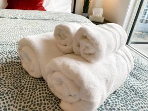 einen Stapel Handtücher auf dem Bett in der Unterkunft Dockside Luxury Living Bedroom Bathroom in Whitby