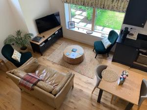 a living room with a couch and a table at Private Apartment at Woodland Retreat in Gamlingay