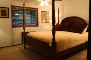 a bedroom with a large bed with a wooden frame at Whitaker 5 bdrm Daily-Weekly-Monthly in Eugene +6 photos