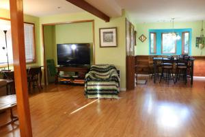 a living room with a tv and a chair and a table at Whitaker 5 bdrm Daily-Weekly-Monthly in Eugene
