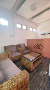 un soggiorno con divano e tavolo di HOMESTAY KIKA SYARIAH PURWOKERTO a Purwokerto