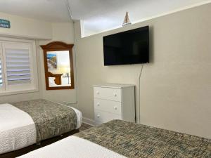 1 dormitorio con 2 camas y TV en la pared en Ocean Front at Beach Cove, en Myrtle Beach