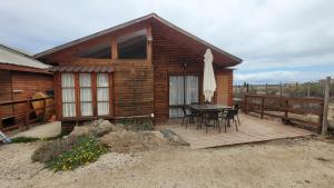 a cabin with a table and chairs on a wooden deck at Casas Rocamar in Totoralillo