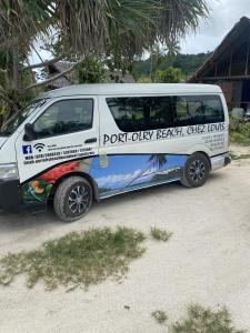 una furgoneta blanca estacionada al lado de una carretera en Port-Olry Beach Bungalows Chez Louis en Port Olry