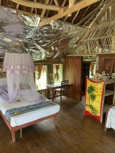 a bedroom with a bed in a room with a ceiling at Port-Olry Beach Bungalows Chez Louis in Port Olry