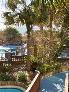 a view of a resort with a pool and palm trees at Ocean Front at Beach Cove in Myrtle Beach