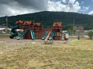 un parque infantil con toboganes y estructuras de juego en un campo en Orchid Inn en Montego Bay