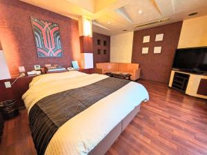 a bedroom with a large bed and a flat screen tv at SKY Ocean-terace Omura in Omura