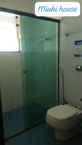 baño con aseo y puerta de ducha de cristal en Casa de Praia com Piscina em Peruíbe, en Peruíbe