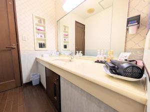 baño con lavabo y espejo grande en SKY Ocean-terace Omura, en Omura