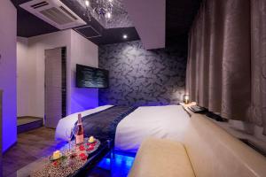 a bedroom with a bed with a couch and a table at Hotel Plantan - Adult Only in Tokyo