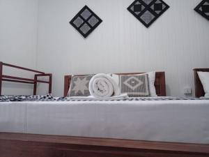 Una cama con almohadas y una toalla encima. en Zuni`s Home Stay, en Kandy