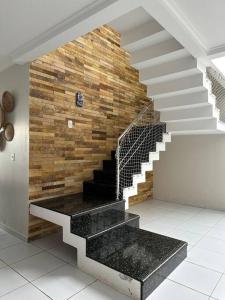 una escalera en una casa con una pared de piedra en Casa Barra de São Miguel - AL, en Barra de São Miguel