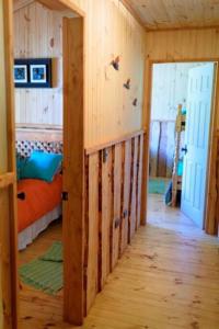 a wooden room with a bed and a hallway at Cabaña en Caburgua in Caburgua