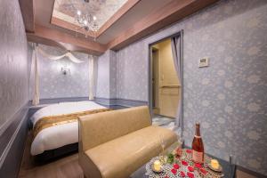 a bedroom with a bed and a couch and a table at Hotel Plantan - Adult Only in Tokyo