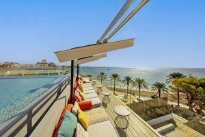 balcón con vistas al océano y a la piscina en W Ibiza, en Santa Eulària des Riu