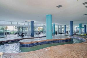 a swimming pool in a building with blue columns at Oceanview Paradise at the Beach in Myrtle Beach