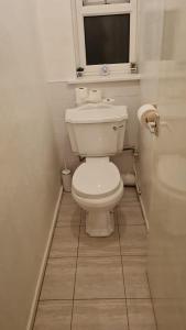 a bathroom with a white toilet and a window at 3BED Maisonette Near CityCentre in Birmingham