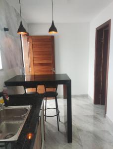 cocina con encimera negra y mesa en Oceano Residence, en Búzios