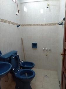 y baño con ducha y 2 aseos azules. en HOSTAL DOÑA BERTA en Humahuaca