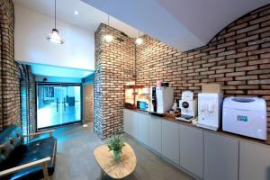 a room with a brick wall and a coffee shop at Hotel Yaja Cheongju Terminal Branch in Cheongju