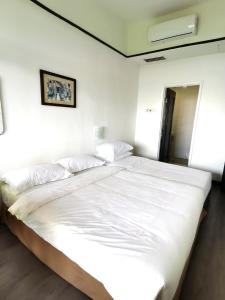 1 cama blanca grande en una habitación blanca en A scenic Malacca retreat (New reno unit Nov 23) en Melaka