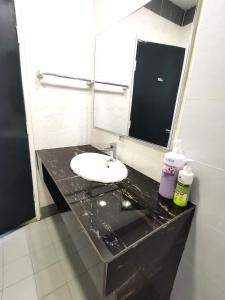 baño con encimera negra con lavabo y espejo en A scenic Malacca retreat (New reno unit Nov 23) en Melaka