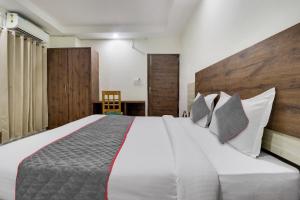a bedroom with a large white bed with pillows at Townhouse Hotel Rooftop in Rishīkesh