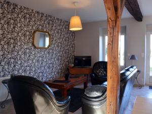 uma sala de estar com cadeiras de couro preto e um espelho em Gîte Oinville-Saint-Liphard, 3 pièces, 4 personnes - FR-1-581-23 