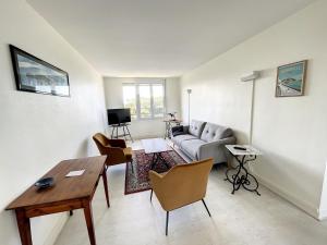 a living room with a couch and a table at Appartement spacieux près de la plage et commerces, 4 couchages - FR-1-361-433 in Donville-les-Bains
