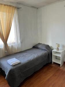 um quarto com uma cama grande e uma janela em Departamentos Arrayán em Chillán