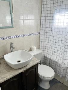 uma casa de banho com um WC branco e um lavatório. em Departamentos Arrayán em Chillán