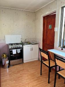 uma cozinha vazia com um fogão e uma mesa em Departamentos Arrayán em Chillán