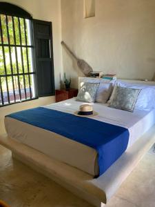 a bedroom with a large bed with a blue blanket at Casa De Amigos Hotel Boutique in Honda