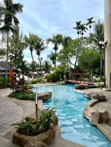 a swimming pool in a resort with palm trees at beachfront sea in Tanjung Bungah