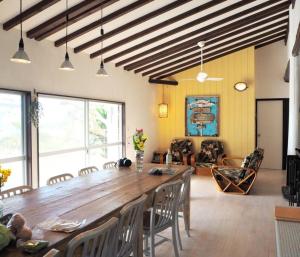 a living room with a large wooden table and chairs at 下田 OKIRAKU HOUSE in Katsura