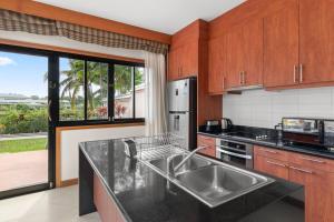 une cuisine avec un évier et une grande fenêtre dans l'établissement Laguna Village 3 Bedroom Villla, à Layan Beach