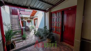 un pasillo vacío con una puerta roja y plantas en Cómodo departamento en Cobija, en Cobija