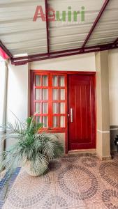 a red door of a building with a plant in front at Cómodo departamento en Cobija in Cobija