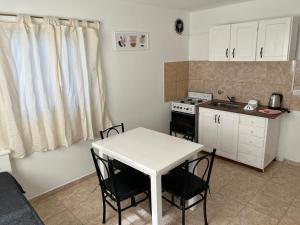 a kitchen with a white table and chairs and a stove at Bella Luna apart in Mina Clavero