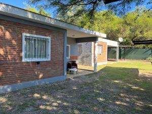 a brick house with a window and a chair at Bella Luna apart in Mina Clavero +6 photos