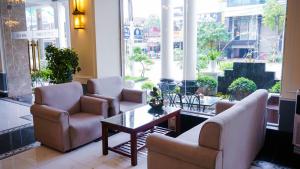 a lobby with chairs and a table and windows at MAY PLAZA HOTEL in Thái Nguyên