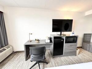 a room with a desk with a television and a chair at Kiteville Cedar Rapids in Cedar Rapids